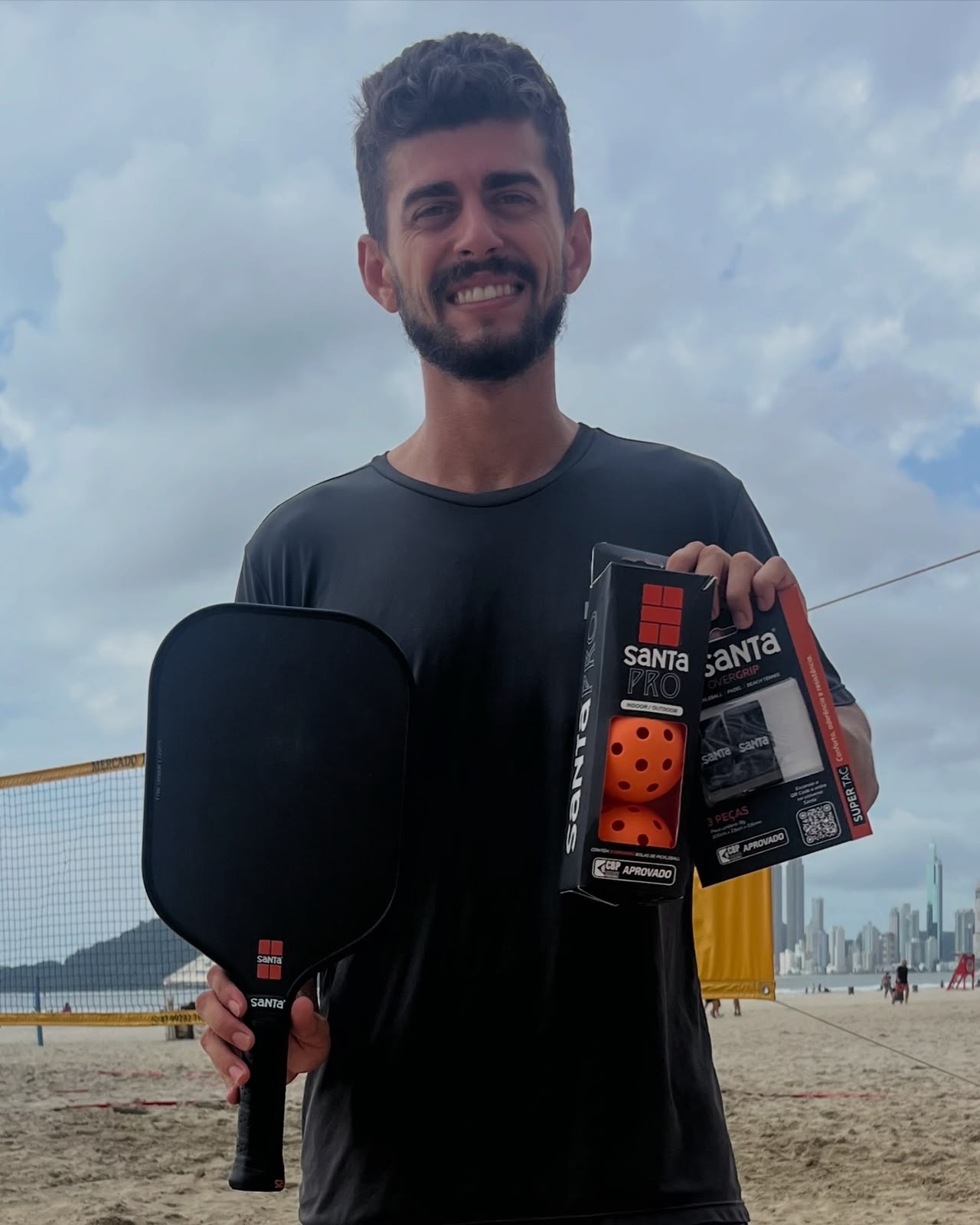 Atleta com raquete e produtos oficiais Santa Esportes na praia
